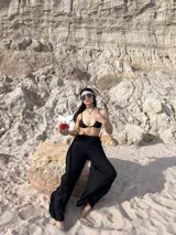 Pantalón negro de tiro alto, corte ancho y fluido, con cintura elástica.