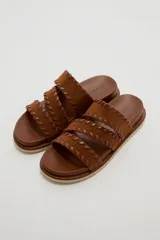 Sandalias planas color negro con tres tiras anchas adornadas con costuras cruzadas en el borde.
