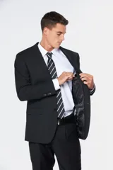 Traje clásico negro de corte fit, compuesto por saco de botonadura simple con bolsillos con solapa y pantalón de vestir a juego.
