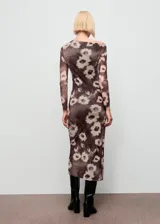 Vestido midi de corte entallado con cuello asimétrico y manga larga. Presenta un diseño drapeado en la cintura y un estampado floral sobre fondo oscuro.