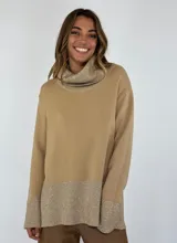 Sweater beige de punto con cuello alto y detalles brillantes en el cuello, puños y dobladillo.