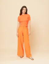 Pantalón de lino color naranja, de tiro alto y corte wide leg.