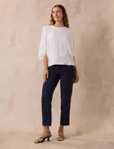 Blusa de gasa con estampado geométrico en tonos negro, gris y celeste. Tiene cuello redondo y mangas 3/4 amplias con abertura y botón.