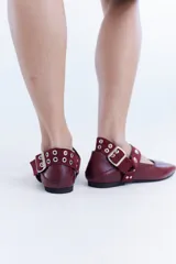 Ballerinas de cuero bordó con puntera cuadrada, diseño destalonado y tira en el empeine decorada con tachas metálicas.