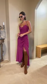 Vestido midi color uva con escote corazón, tirantes finos y aberturas laterales en la cintura. Presenta un diseño con frunces frontales y una falda con tajo lateral.