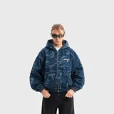 Campera canguro de denim con capucha, cierre frontal completo y bolsillos tipo parche, confeccionada en tela 100% algodón con diseño de camuflaje en tonos azules y detalles bordados.