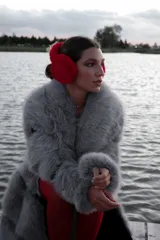 Chaqueta gris de piel sintética con cuello solapa y cierre cruzado con botones a presión.