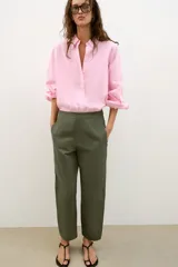 Pantalón de tiro medio con diseño barrel, pernera holgada que se estrecha hacia el tobillo, bolsillos delanteros y bolsillos de plastrón en la espalda. Confeccionado en tejido con textura de espiga, cuenta con cierre frontal de cremallera, botón interior y gancho.
