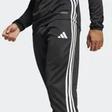 Pantalón de jogging negro Adidas Tiro 25 Essentials con tres rayas blancas en los laterales, corte ajustado y bolsillos con cierre.