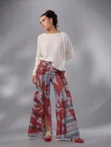 Pantalón de cintura alta y piernas amplias en lino mezcla, con estampado vegetal en tonos bordó, gris y blanco, y tajos asimétricos en las piernas. Cuenta con cierre invisible lateral y bolsillos.