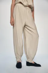 Pantalón de tiro medio con cintura elástica, bolsillos delanteros y bajo acabado en puño con lazada ajustable.