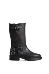 Borcego de cuero color marrón con apliques plateados, caña alta y suela track.