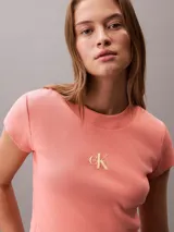 Remera cropped de Calvin Klein, color salmón, con cuello redondo, manga corta y logo de la marca bordado en el centro del pecho.