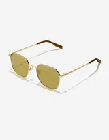 Lentes de sol con marco metálico dorado de forma geométrica y cristales en tono amarillento. Presentan patillas finas con terminales en color marrón.
