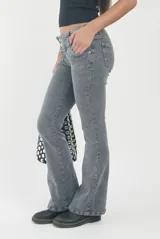 Pantalón de jean gris oscuro con efecto lavado, corte tiro bajo y diseño acampanado con bolsillos frontales decorativos.