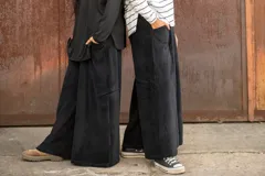 Pantalón tipo palazzo de tiro alto, confeccionado en plush de algodón con lycra. Presenta un corte amplio y fluido, con bolsillos laterales y una faja ancha en la cintura que proporciona ajuste y comodidad.