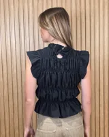 Blusa sin mangas de diseño estructurado con múltiples líneas de frunces y elásticos horizontales, cuello alto con volado y diseño ajustado. Presenta estampado de rayas verticales.