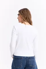 Remera de manga larga con cuello redondo y ajuste al cuerpo, confeccionada en tejido de algodón con textura acanalada.