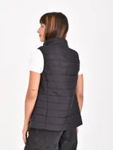 Chaleco puffer negro con cuello alto y cierre frontal.