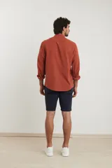 Camisa de cuello mao y manga larga, confeccionada en una mezcla de lino y algodón. Presenta un diseño de corte recto con botones en tono natural y un bolsillo pequeño en el pecho.