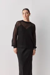 Falda midi color negro al bies, confeccionada en tela de textura suave y caída fluida, de diseño minimalista y silueta recta.