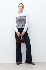 Top strapless (sin tirantes) de mujer, ajustado al cuerpo con efecto fruncido (smock) en todo el torso y un pequeño volante en el ruedo inferior. Presenta un estampado de cebra en blanco y negro.