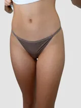 Colaless estilo string de tiro bajo, confeccionada en microfibra elástica con cintura elástica personalizada con el logo de la marca en tono a tono.