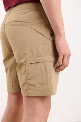 Bermuda color beige con bolsillos laterales tipo cargo, corte recto y cintura elástica.