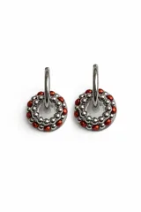 Aros tipo argolla con dije circular compuesto por una base de resina transparente, rodeada por una hilera de cuentas de acero inoxidable y una hilera exterior de cristales de murano color rojo.