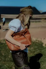 Cartera tipo canasto color marrón, hecha en 100% cuero con diseño tejido. Tiene bolsillo interno, porta llaves y cierre.