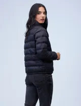 Campera de plumas reversible marca Michael Kors. Un lado es liso y el otro estampado con el logo de la marca. Tiene abertura central con cierre metálico, bolsillos delanteros y avíos metálicos con el logo. Incluye bolsa autoportante.