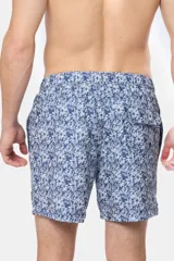 Short de baño celeste con estampado de flores blancas, cintura elástica con cordón ajustable, dos bolsillos laterales y suspensor de malla fina.
