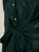 Vestido camisero largo negro con botones nacarados, lazo en la cintura y detalle de Polonio en cobre.