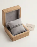 Pulsera esclava de acero con diseño de doble cadena de eslabones entrelazados.