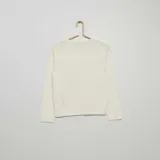 Chaqueta de punto fino color blanco con botones dorados.