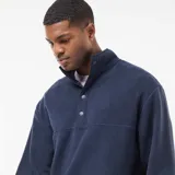 Sweater de polar azul marino con cuello camionero y cierre frontal de botones a presión. Diseño de manga larga y calce holgado.