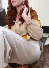 Sweater de punto con diseño geométrico en tonos mostaza, marrón y beige.