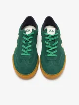 Championes Veja modelo Volley, confeccionados en gamuza color verde con detalles en crema. Presentan el logo lateral en forma de V, suela de goma color caramelo y cierre mediante cordones.