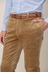 Pantalón de corte regular confeccionado en tela de corduroy color beige, con bolsillos laterales y presillas para cinturón.