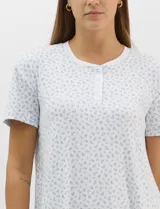 Camisón corto René Rofé de corte recto y textura acanalada, color blanco con estampado floreado en tonos celestes. Con mangas cortas, escote redondo y pechera frontal con abotonadura parcial.