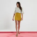 Minifalda color beige con cierre lateral de botones.