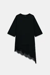 Camiseta negra de algodón con cuello redondo y manga corta. Presenta un bajo asimétrico con aplicación de encaje negro a tono.