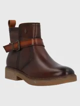 Bota corta de cuero color marrón con acabado desgastado, detalle de tira con hebilla metálica en el tobillo y suela de goma texturizada.