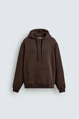 Sudadera tipo hoodie de corte relajado, confeccionada en tejido de algodón con interior cepillado. Presenta capucha con cordones ajustables, bolsillo frontal tipo canguro y terminaciones en rib en puños y ruedo.