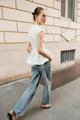 Top blanco sin mangas con cuello perkins y bajo con volado tipo peplum.