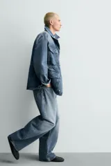 Jeans de denim de algodón, tiro medio, con corte barrel fit amplio en cadera y muslos que se estrecha hacia el tobillo. Presenta efecto lavado y cierre frontal con botones.