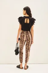 Pantalon estilo babucha con estampado de piel de serpiente, cintura elastizada con cordón de ajuste y bolsillos diagonales frontales.