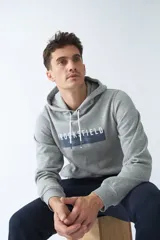 Buzo canguro de felpa color bordó, con capucha ajustable con cordones blancos, fit regular, manga larga, bolsillo canguro y logo estampado en el pecho.