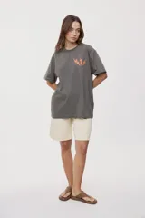 Remera de manga corta con calce oversized y cuello redondo, color gris oscuro, con pequeño gráfico de rayos naranjas en el frente.