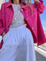 Camisa fucsia con calados, de corte recto, con cuello camisero, cierre frontal con botones y bolsillo de parche en el pecho.
